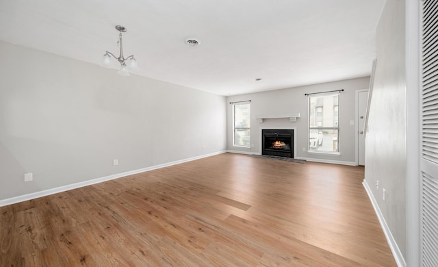 7222 Woods Crossing Dr, Roanoke, VA 24018 - unfurnished living room featuring light wood-style flooring, a fireplace with flush hearth, visible vents, a chandelier, and baseboards