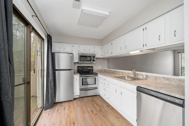 7222 Woods Crossing Dr, Roanoke, VA 24018 - kitchen with visible vents, appliances with stainless steel finishes, light countertops, a sink, and light wood finished floors