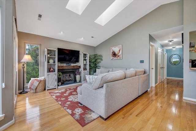114 Waterside Cir Unit B-6, Moneta, VA 24121 - living area featuring a skylight, light wood finished floors, a glass covered fireplace, baseboards, and high vaulted ceiling