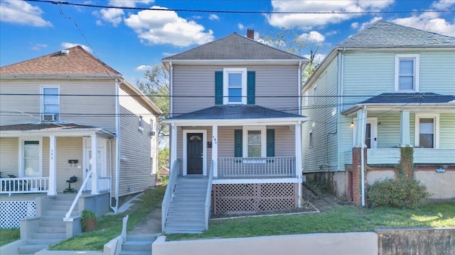 view of front of property featuring stairway, a porch, and a shingled roof