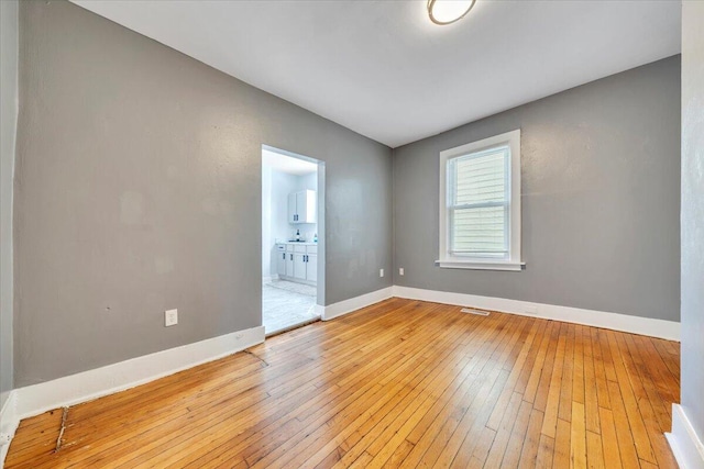 empty room with light wood-type flooring and baseboards