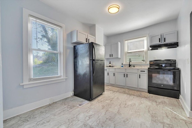 kitchen with under cabinet range hood, marble finish floor, a sink, and black appliances
