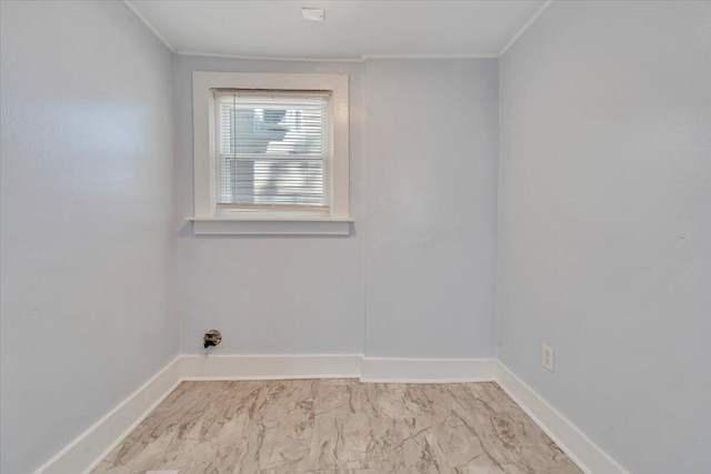spare room featuring marble finish floor, baseboards, and ornamental molding