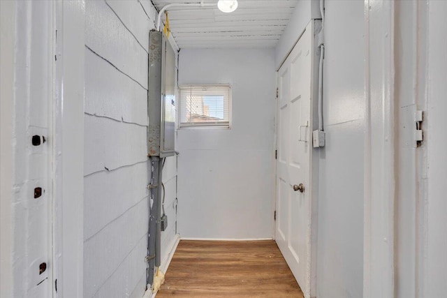 corridor with light wood finished floors and electric panel