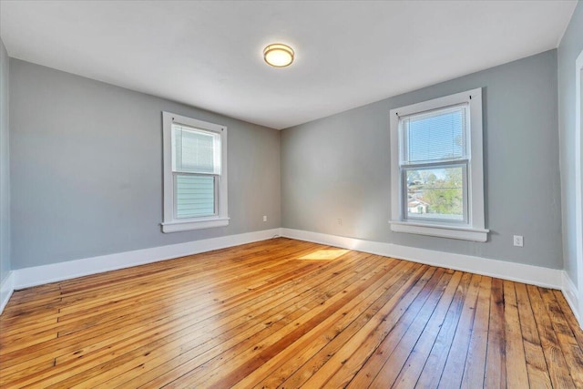 unfurnished room with baseboards and hardwood / wood-style floors