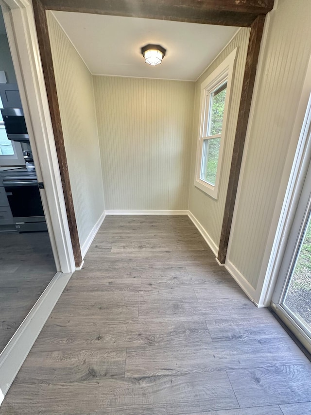 unfurnished dining area featuring baseboards and wood finished floors