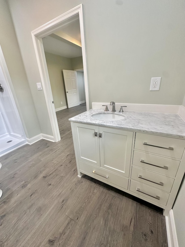 bathroom featuring baseboards, vanity, and wood finished floors