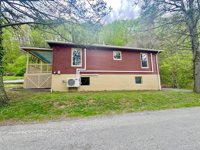 view of property exterior with ac unit and a wooded view