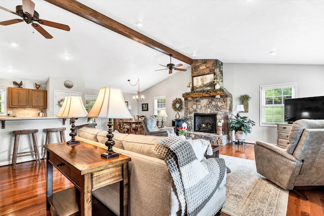 living room featuring a fireplace, wood finished floors, vaulted ceiling with beams, and ceiling fan with notable chandelier
