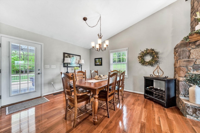 dining area with visible vents, baseboards, wood finished floors, and a chandelier