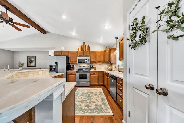kitchen with stainless steel appliances, a sink, decorative backsplash, lofted ceiling with beams, and ceiling fan