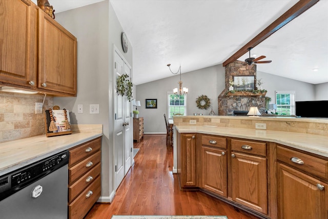 kitchen featuring lofted ceiling with beams, backsplash, ceiling fan with notable chandelier, brown cabinets, and dishwasher