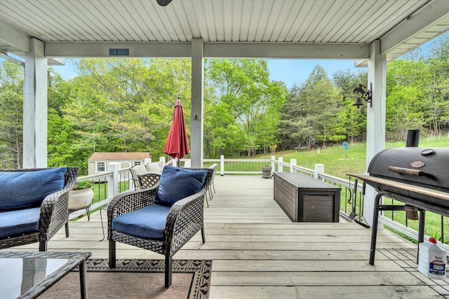 deck featuring an outbuilding, a storage shed, a yard, and area for grilling