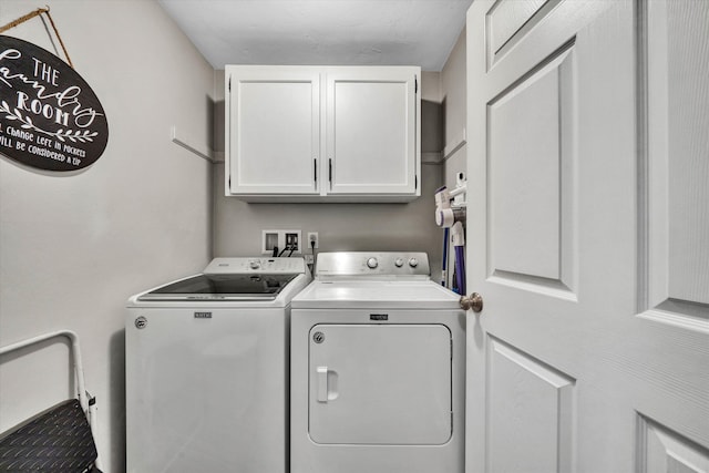washroom with cabinet space and washer and dryer