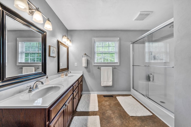 bathroom featuring visible vents, a sink, and a shower with door
