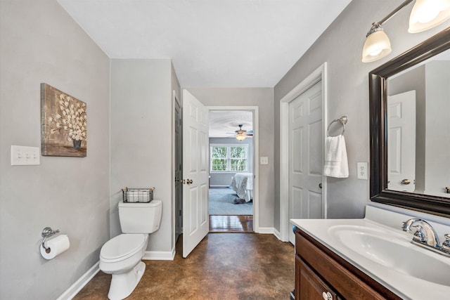 ensuite bathroom featuring toilet, baseboards, finished concrete floors, vanity, and connected bathroom