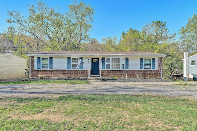 ranch-style house featuring brick siding and a front lawn