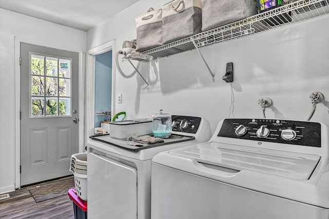 laundry room with washing machine and dryer, laundry area, and wood finished floors