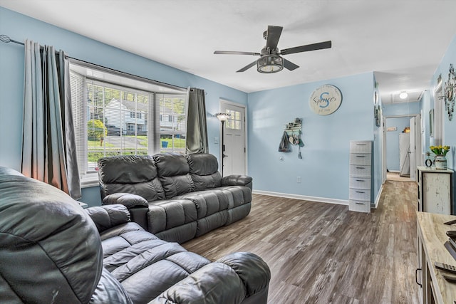 living area with baseboards, attic access, a ceiling fan, and wood finished floors