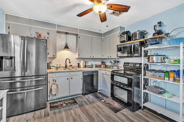 kitchen with tasteful backsplash, appliances with stainless steel finishes, a sink, and a ceiling fan