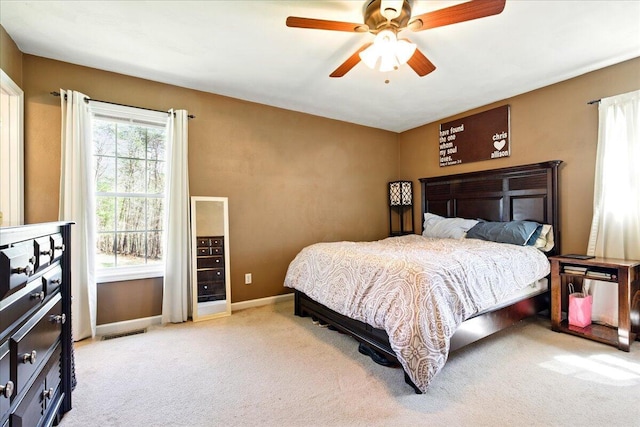 bedroom with visible vents, baseboards, ceiling fan, and light carpet