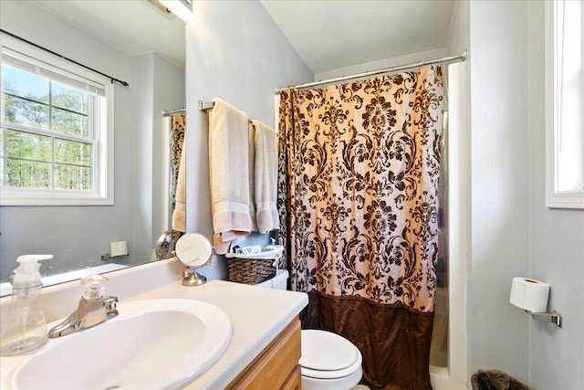 bathroom featuring toilet, vanity, and a shower with curtain