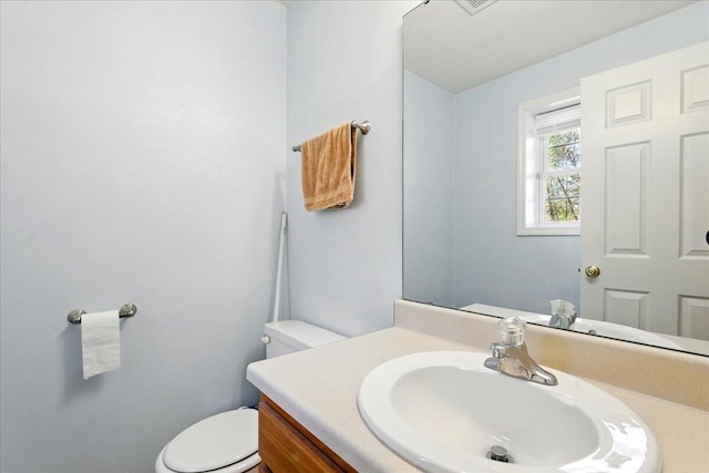 half bathroom with vanity and toilet