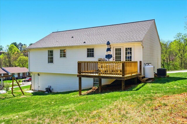 back of property with a shingled roof, central AC unit, a wooden deck, and a lawn