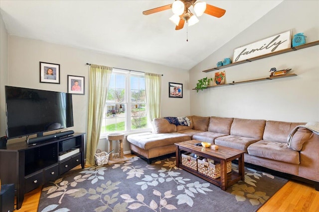 living room featuring light wood finished floors, a ceiling fan, and lofted ceiling