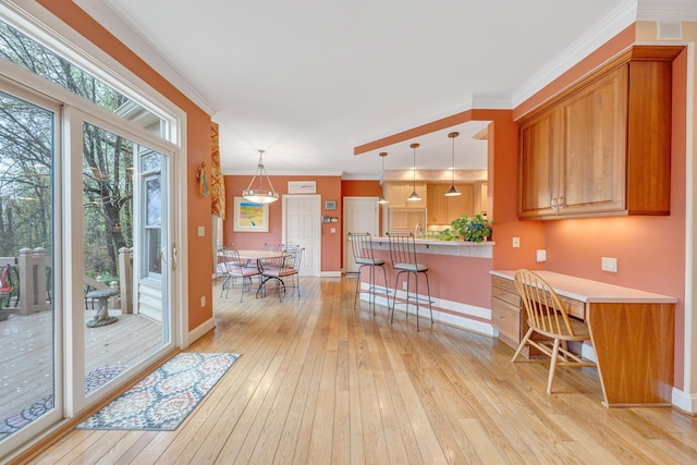 3649 Peakwood Dr SW, Roanoke, VA 24014 - kitchen featuring a breakfast bar area, light wood-style flooring, a peninsula, decorative light fixtures, and crown molding