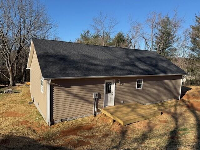 rear view of house featuring crawl space and roof with shingles