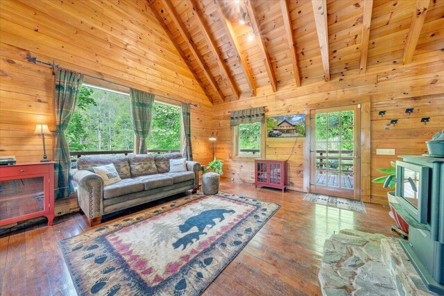 living room featuring beamed ceiling, wood walls, and wooden ceiling