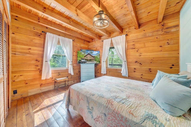 bedroom with wood ceiling, hardwood / wood-style flooring, multiple windows, and beamed ceiling