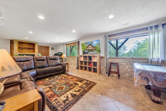 tiled living area with visible vents, recessed lighting, and a textured ceiling