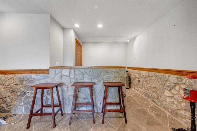 bar with wainscoting and tile patterned floors