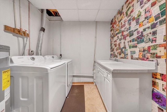 laundry area featuring cabinet space, electric water heater, a sink, and independent washer and dryer
