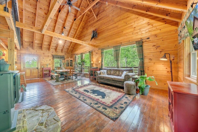 living area featuring beamed ceiling, wooden ceiling, wood walls, and high vaulted ceiling