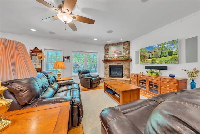 living area featuring a stone fireplace, wood finished floors, ceiling fan, and crown molding