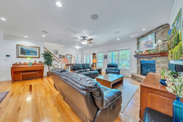 living room featuring recessed lighting, a stone fireplace, light wood finished floors, and ceiling fan