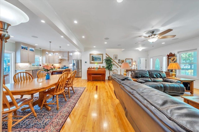 living room featuring a ceiling fan, a healthy amount of sunlight, light wood-style flooring, and recessed lighting
