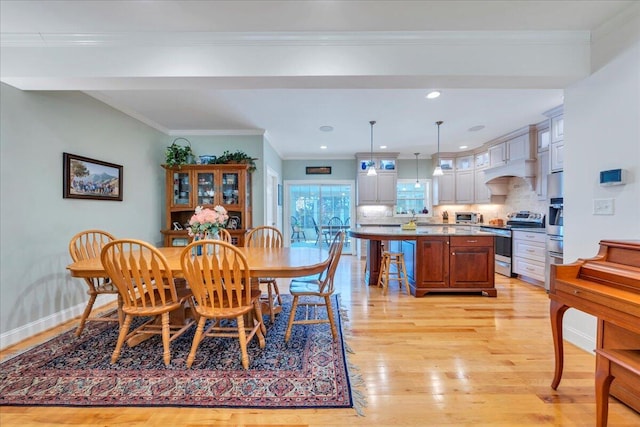dining room featuring recessed lighting, a toaster, light wood-type flooring, crown molding, and baseboards