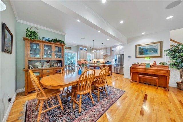 dining room with recessed lighting, light wood finished floors, baseboards, and ornamental molding