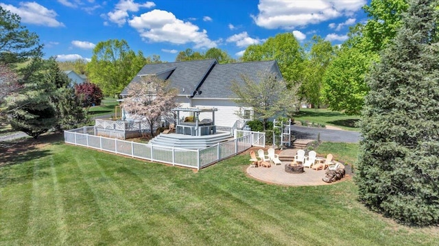 back of house featuring fence, an outdoor fire pit, a yard, and a patio