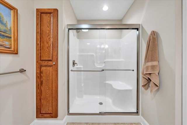 bathroom featuring baseboards and a shower stall