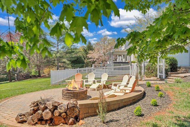 view of yard featuring fence, a fire pit, and a patio