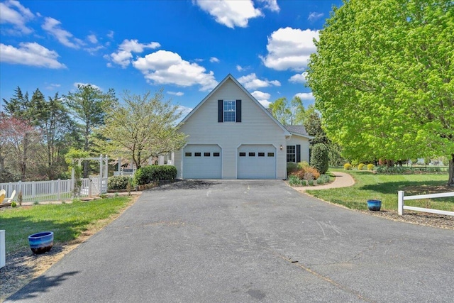 view of front facade with an attached garage, fence, driveway, and a front yard