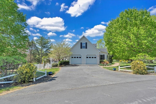 view of front of house featuring fence, driveway, and a garage