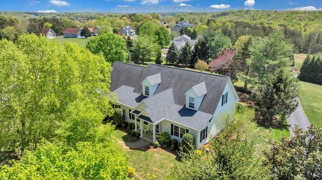 birds eye view of property featuring a view of trees