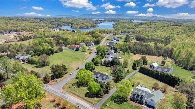 drone / aerial view featuring a view of trees and a water view
