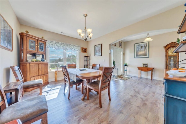 398 River Ridge Rd SE, Copper Hill, VA 24079 - dining space with arched walkways, light wood-type flooring, a chandelier, and baseboards